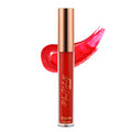 A tube of brick red lip gloss with a golden cap, alongside a swatch of the product showing its glossy texture.