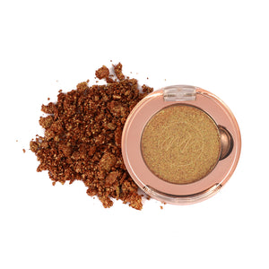 A single pink-colored eyeshadow pan with a shimmery, glittery finish, surrounded by loose brown eye shadow particles.