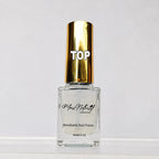 A bottle of Marc Motori Breathable Nail Polish with a shiny gold cap and clear glass bottle, labeled 'TOP' on the cap, set against a plain white background.