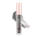 A pink-bottled liquid eye shadow with a black glittery formula, shown with a applicator wand coated in the product.