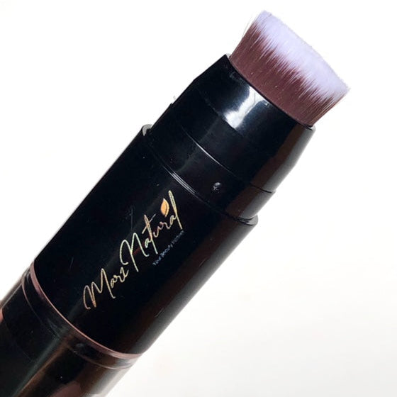 Makeup brush with black handle and pink bristle tip on a white background