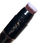 Makeup brush with black handle and pink bristle tip on a white background